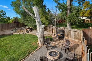 Fenced backyard featuring a fire pit and a patio area
