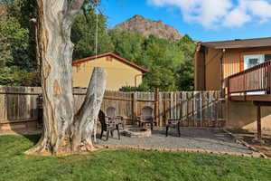 Fenced backyard featuring a mountain view and an outdoor fire pit