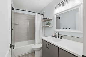 Bathroom with shower / bath combo, vanity, and light wood-style flooring
