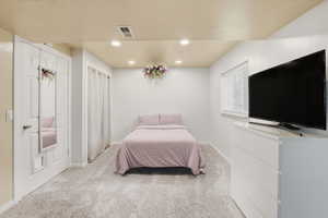 Bedroom featuring carpet, a textured ceiling, and recessed lighting