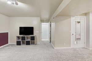 Below grade area featuring light colored carpet and a textured ceiling