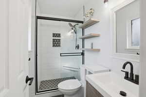 Bathroom featuring a shower stall and vanity
