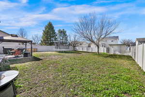Fenced backyard with a patio area, a gazebo, and a storage unit