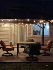 View of patio with outdoor dining area. Gazebo, outdoor fan and lighting is included.