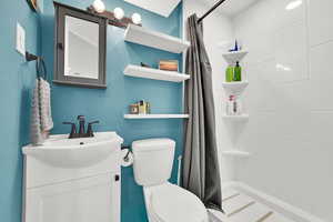 Full bath featuring a shower stall and vanity