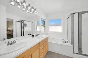 Full bath with double vanity, ensuite bath, a shower stall, and a jetted bath