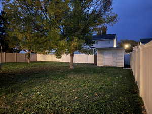 Fenced back yard with shed and mature trees