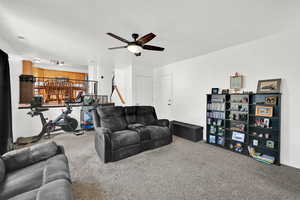 Carpeted living area with a ceiling fan