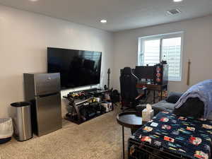 Living room featuring light carpet, recessed lighting, and a textured ceiling
