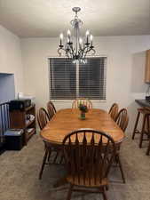 Dining space featuring a textured ceiling and a chandelier