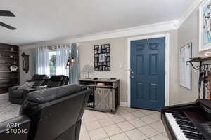 Living room featuring light tile patterned floors and ornamental molding