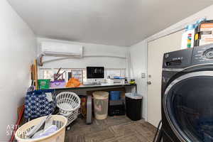 Washroom with washer / dryer, carpet floors, a wall mounted AC, and a desk