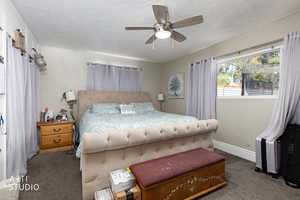 Bedroom featuring carpet, ceiling fan, and a textured ceiling