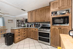 Kitchen with double oven range, a peninsula, brown cabinetry, light tile patterned flooring, and crown molding