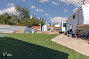 View of grassy yard featuring a storage shed