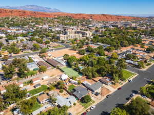 Aerial view of property and surrounding area with mountains and nearby suburban area