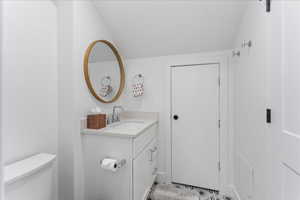Bathroom featuring vanity and lofted ceiling