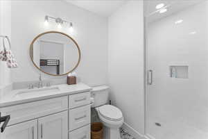 Full bath with a shower stall, vanity, and recessed lighting
