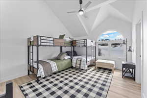Bedroom featuring light wood finished floors, high vaulted ceiling, and a ceiling fan