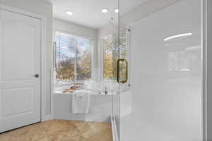 Primary bathroom with a stall shower and a garden tub
