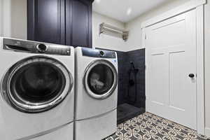 Washroom with separate washer and dryer, cabinet space, and tile patterned flooring with tiled doggie shower.