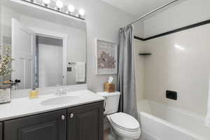 Bathroom with shower / bath combo with shower curtain and vanity