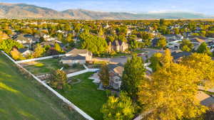 Aerial view of property and surrounding area with a mountain backdrop and nearby suburban area