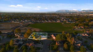Aerial perspective of suburban area with property boundaries highlighted and a mountainous background