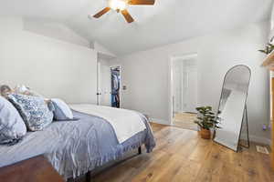 Primary Bedroom with wood-type flooring, lofted ceiling, a spacious closet, and ceiling fan
