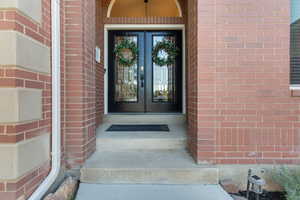 View of exterior entry with brick siding and french doors
