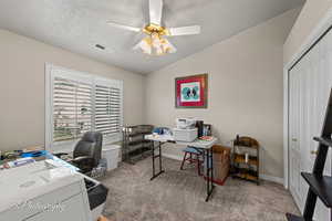 Home office with light carpet, vaulted ceiling, a textured ceiling, and a ceiling fan