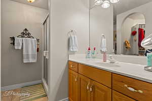 Full bath featuring vanity, a shower stall, and tile patterned flooring