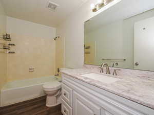 Full bath featuring shower / tub combination, dark wood-style floors, vanity, and a textured ceiling