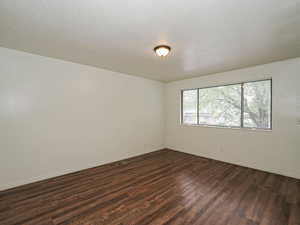 Spare room featuring a textured ceiling and wood finished floors