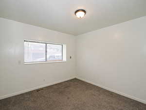 Spare room with neutral carpet and a textured ceiling