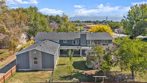 Aerial view of property and surrounding area featuring a tree filled landscape