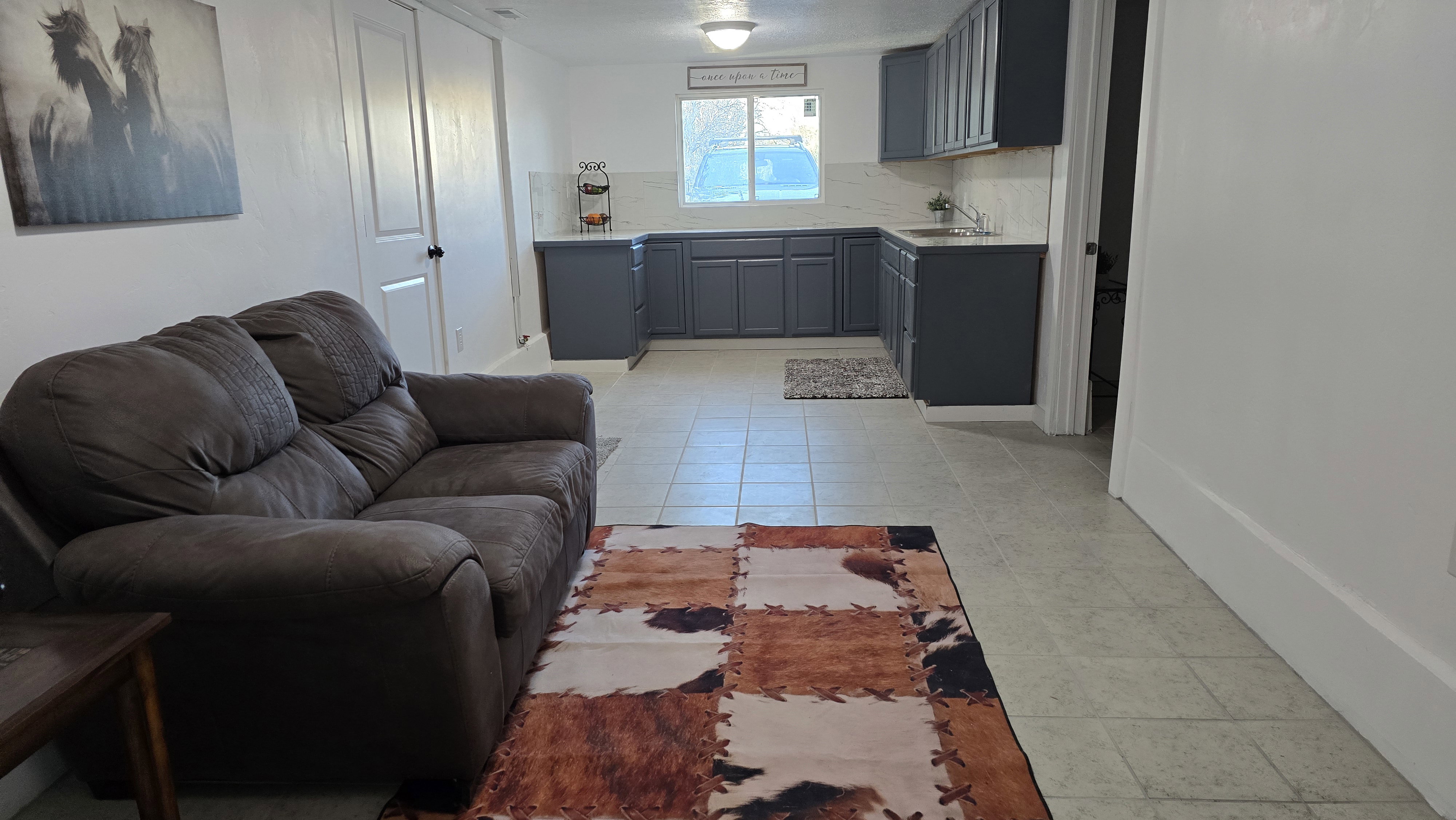 Open concept living area with light-toned tile flooring throughout