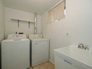 Laundry room featuring washing and dryer (included), and utility sink