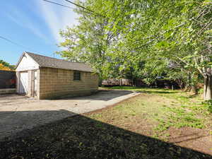 Fully fenced backyard featuring a 1-car garage and workbench