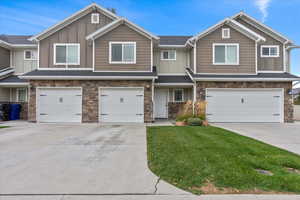 Craftsman house with board and batten siding, concrete driveway, stone siding, and an attached garage