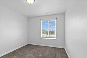 Carpeted spare room with baseboards