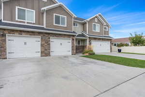Craftsman house featuring stone siding, board and batten siding, concrete driveway, and an attached garage