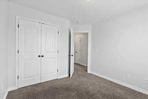Unfurnished bedroom featuring carpet and a closet