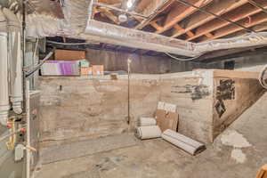Unfinished below grade area featuring heating unit