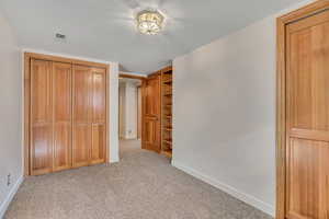 Unfurnished bedroom with light colored carpet and a closet