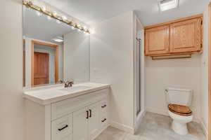 Full bath featuring vanity, a stall shower, and light tile patterned floors