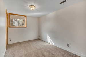 Carpeted empty room featuring baseboards