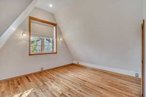 Additional living space with vaulted ceiling, wood finished floors, and recessed lighting