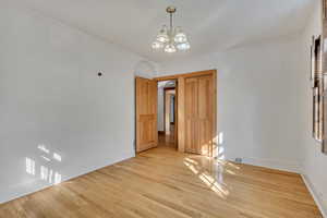 Unfurnished dining area featuring wood finished floors, arched walkways, and a chandelier