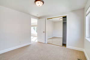 Unfurnished bedroom with carpet and a closet